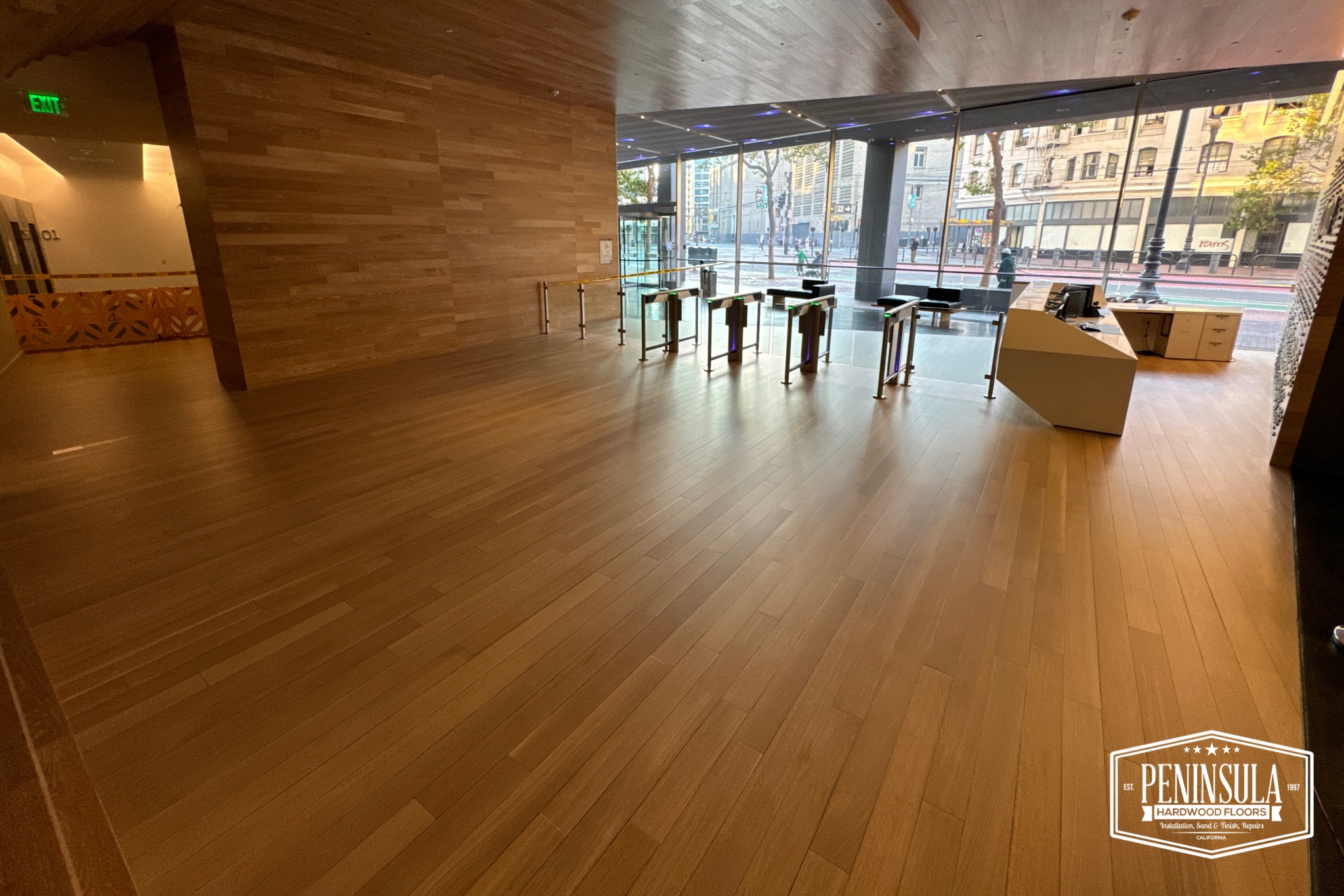 Finished commercial lobby with rich wood accent walls and floors